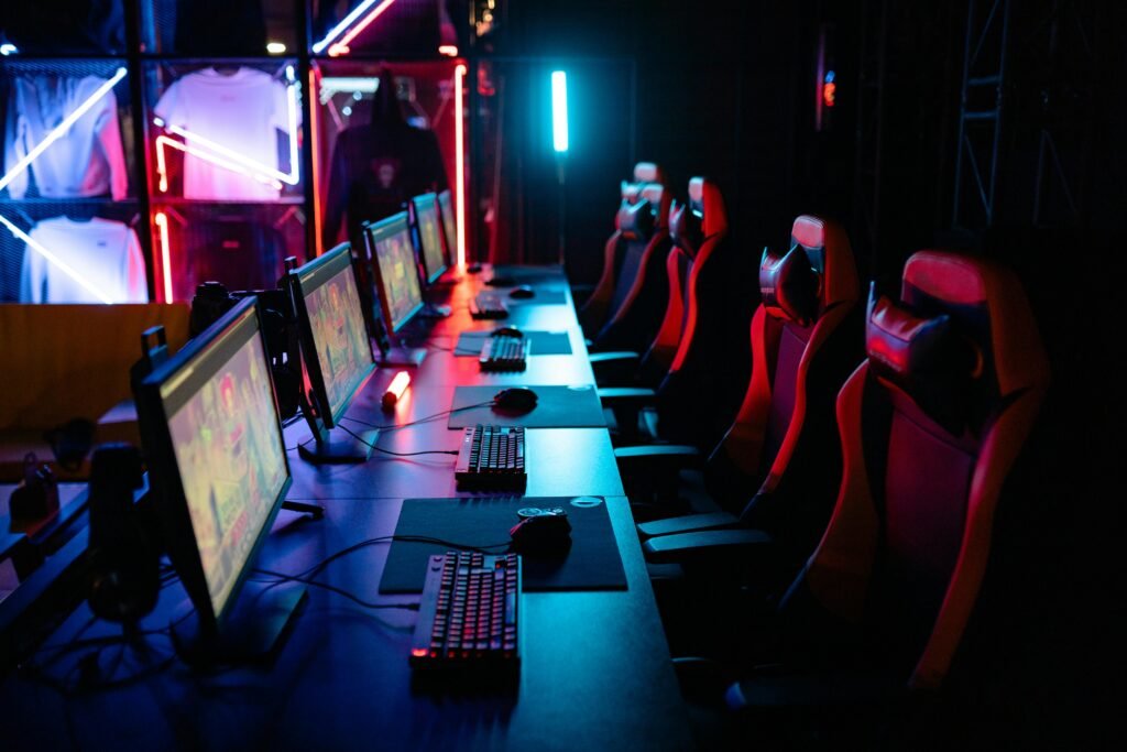 Categories High-tech gaming setup with PCs, RGB lighting, and gaming chairs in a gaming house.